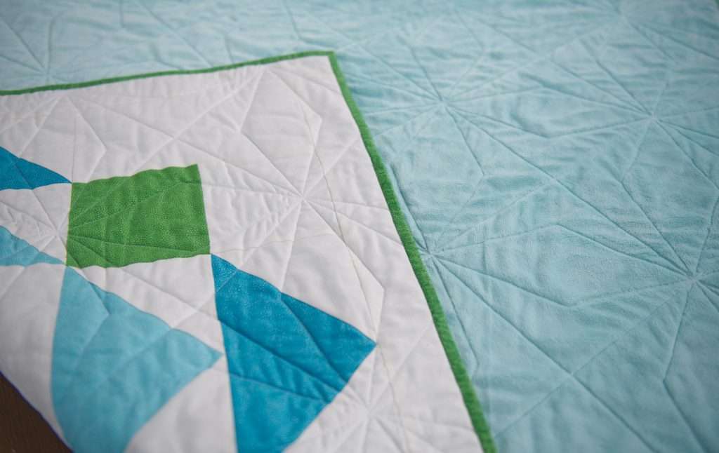 paradigm quilt pattern by homemade emily jabe is a great modern baby boy quilt pattern. If you're looking for an easy quilt pattern that features modern quilt pattern design, the Paradigm quilt pattern is perfect for you! this easy baby quilt was quilted with a fun geometric quilting design and backed with cozy minky fabric