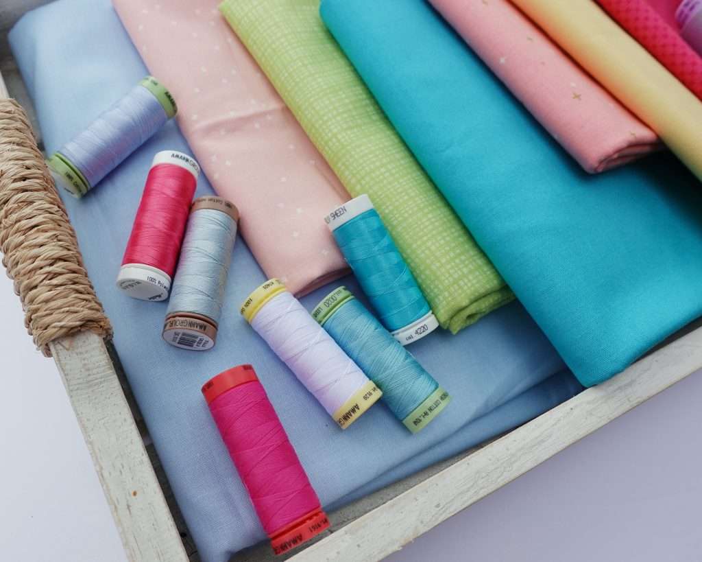 different types of brightly colored threads for making a quilt