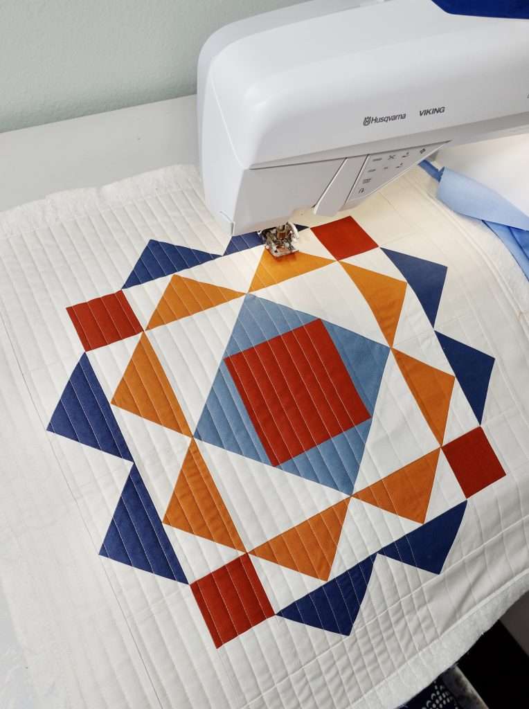 straight line quilting on the Modern Wall Hanging Quilt made from the paradigm quilt pattern by homemade emily jane. This is a modern quilt wall hanging pattern that features flying geese quilt blocks and an economy quilt block.