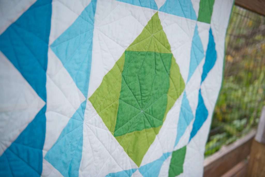 paradigm quilt pattern by homemade emily jabe is a great modern baby boy quilt pattern. If you're looking for an easy quilt pattern that features modern quilt pattern design, the Paradigm quilt pattern is perfect for you! this easy baby quilt was quilted with a fun geometric quilting design and backed with cozy minky fabric